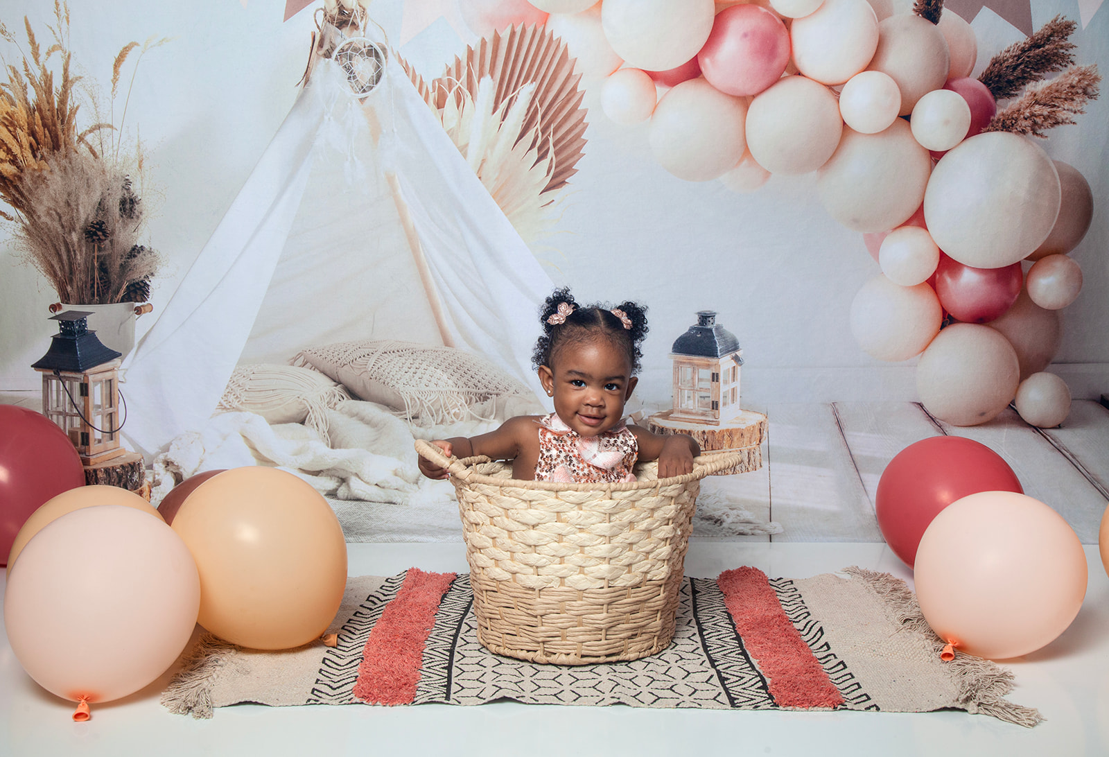 Baby sitting in basket while being surrounded by balloons
